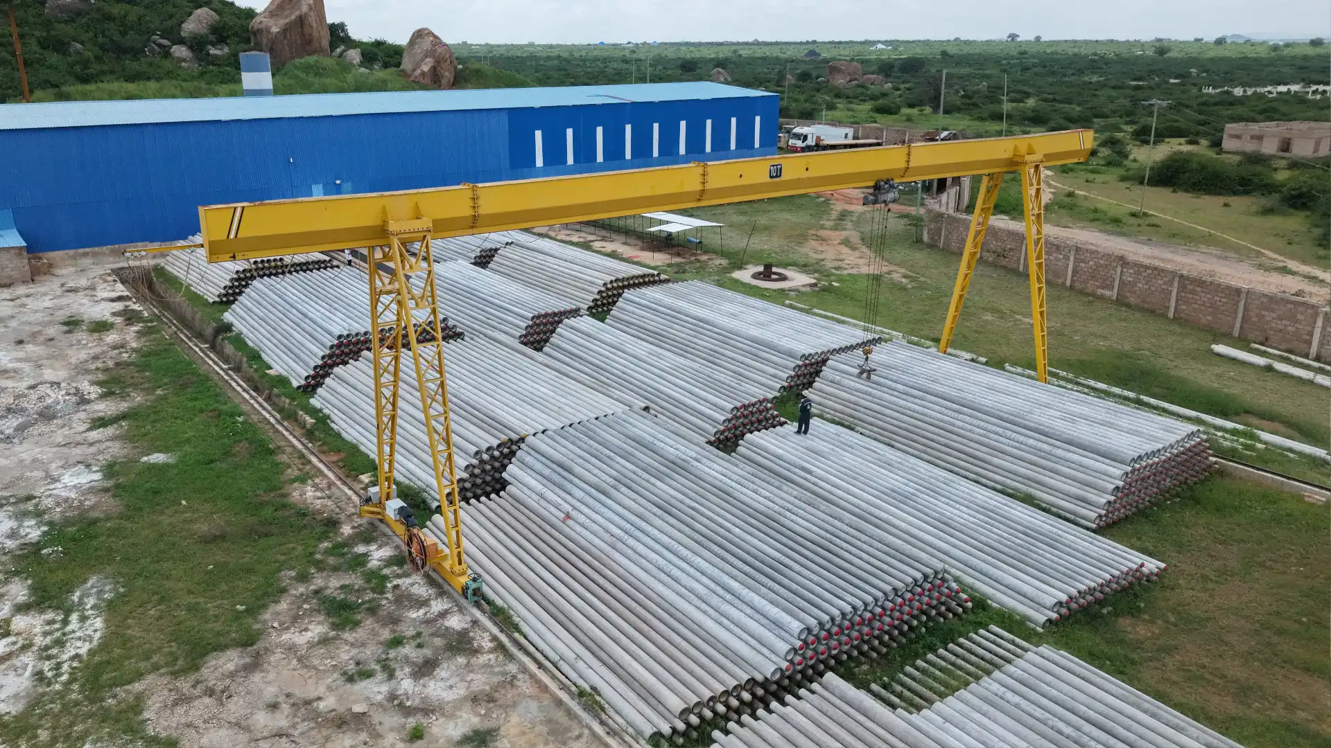 Massive outdoor stockyard with TANESCO-compliant spun concrete poles.