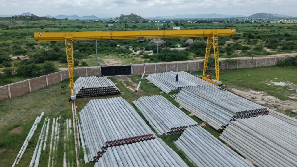 Massive outdoor stockyard with TANESCO-compliant spun concrete poles.