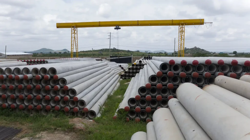 Massive outdoor stockyard with TANESCO-compliant spun concrete poles.