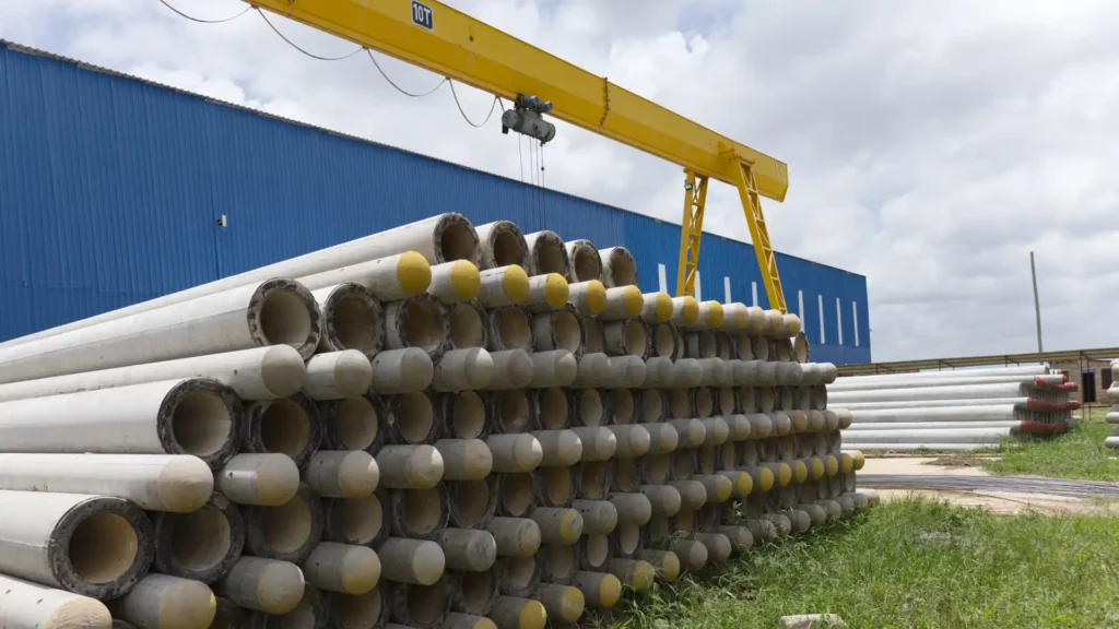 Massive outdoor stockyard with TANESCO-compliant spun concrete poles.