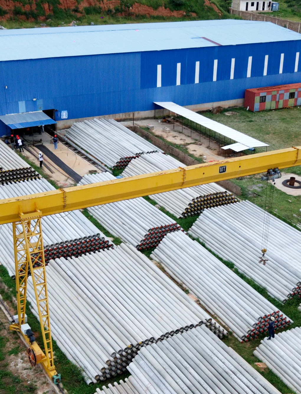 Massive outdoor stockyard with TANESCO-compliant spun concrete poles.